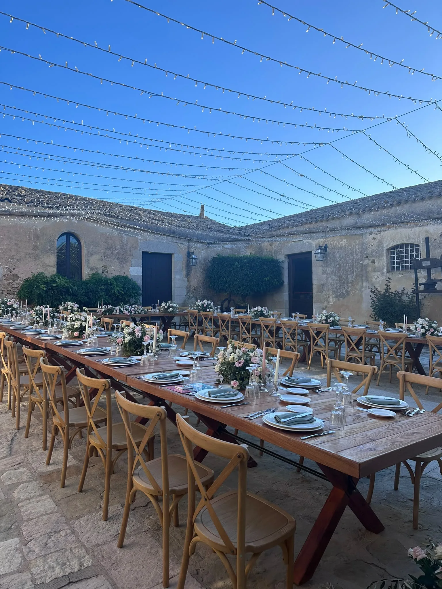 Outdoor reception table set under string lights