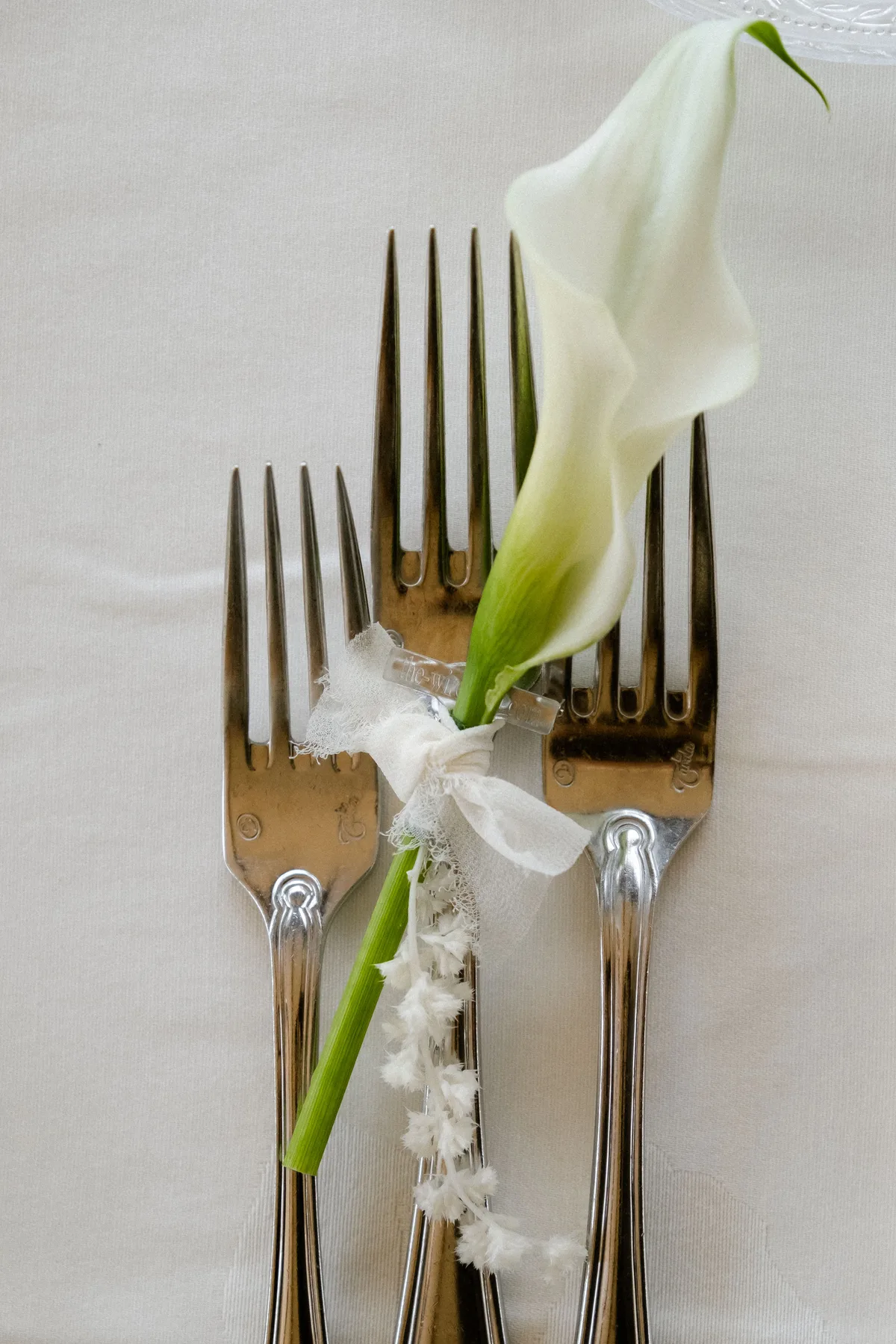 Place-setting forks tied with a calla lily